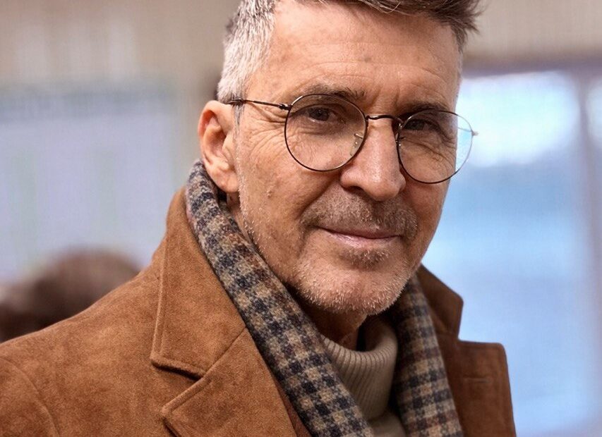 Vacation as Ransom. Why Your Two Weeks Off Are Delaying Your Escape Executive trapped in Moscow City glass tower gazes at beach escape, golden chain links him to '2 Weeks Off' calendar—corporate burnout ransom visualized. Noir cyberpunk style