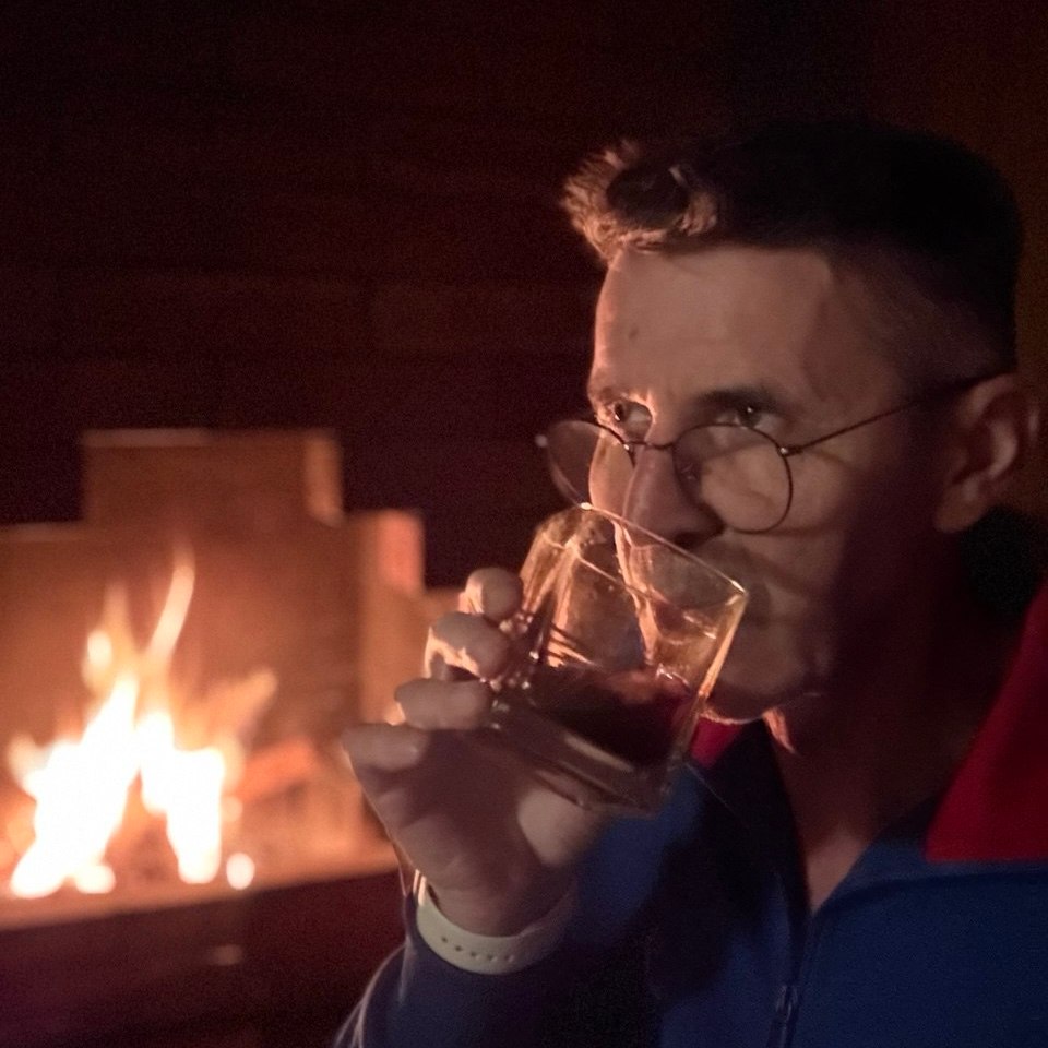 Rainy Moscow street in 2025 with an expat checking a banking app and delivery couriers rushing by — symbolizing the salary gap and cost of living in the city.